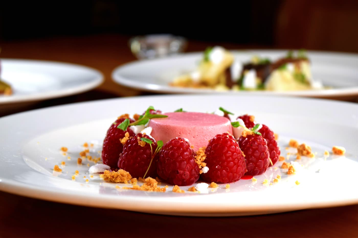 Chef's dessert with fresh raspberries, served on a white plate