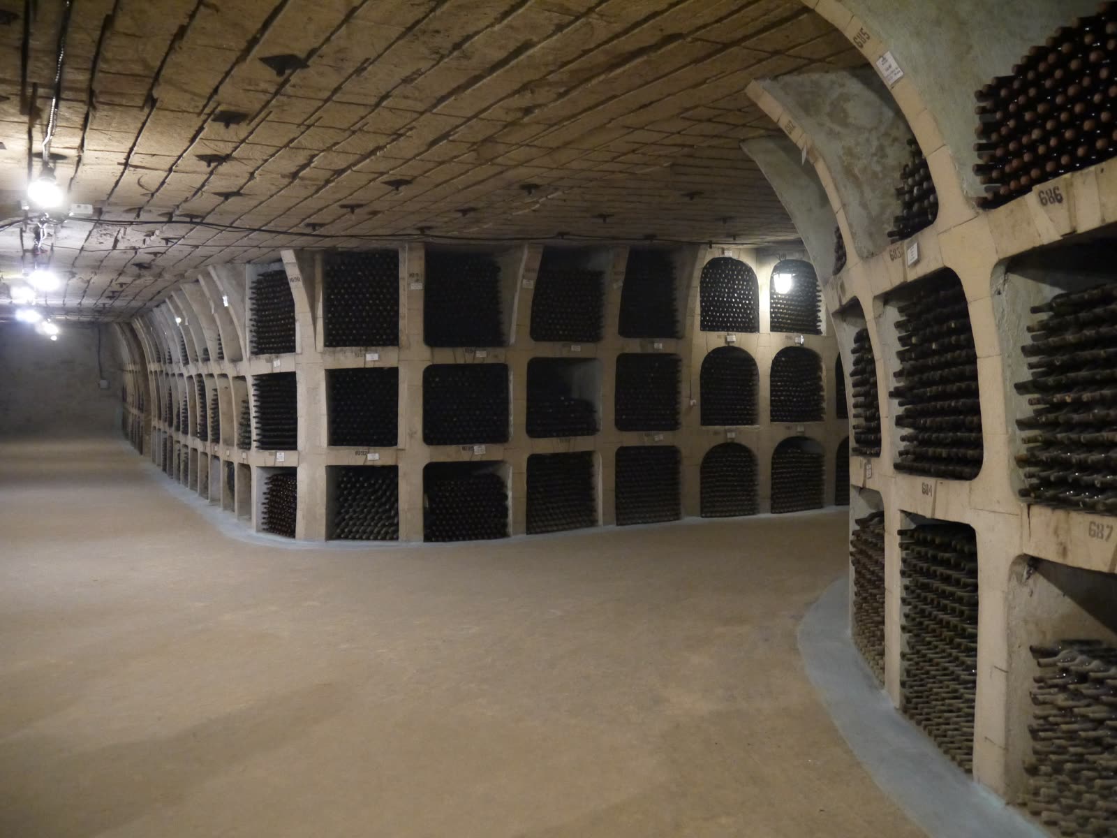 Arched wine cellar corridor lined with racks of bottles