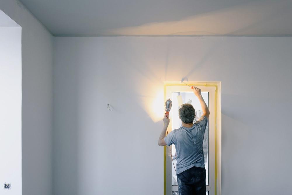 Ilie verifică peretele cu lampa, lângă tocul ușii