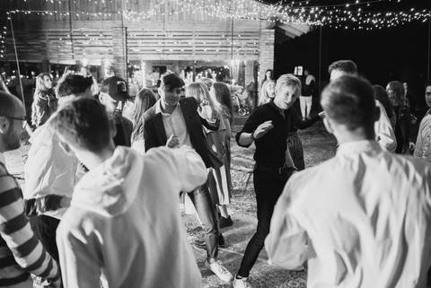 Alb-negru: invitați care dansează sub ghirlande