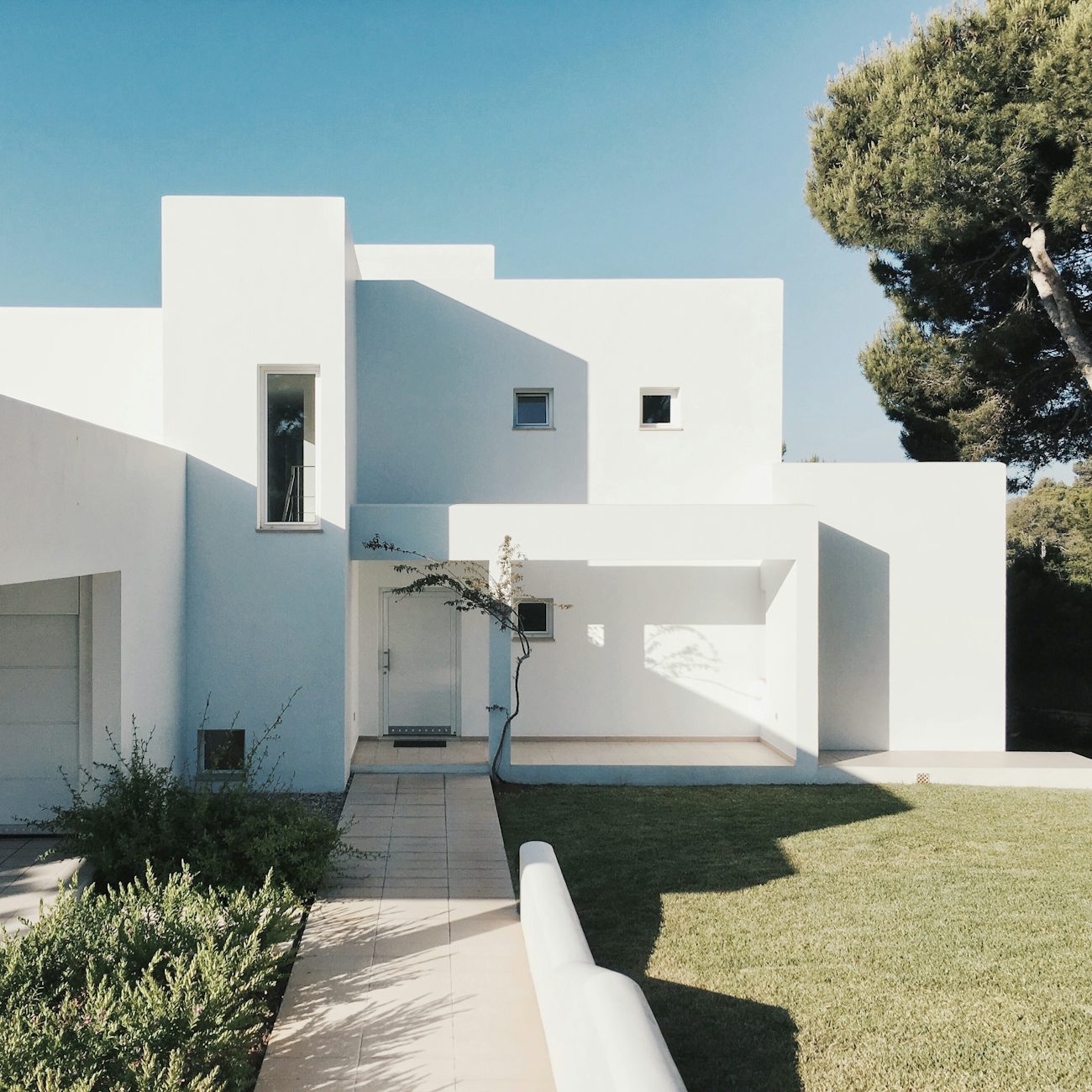 Minimalist white cubic house against a blue sky