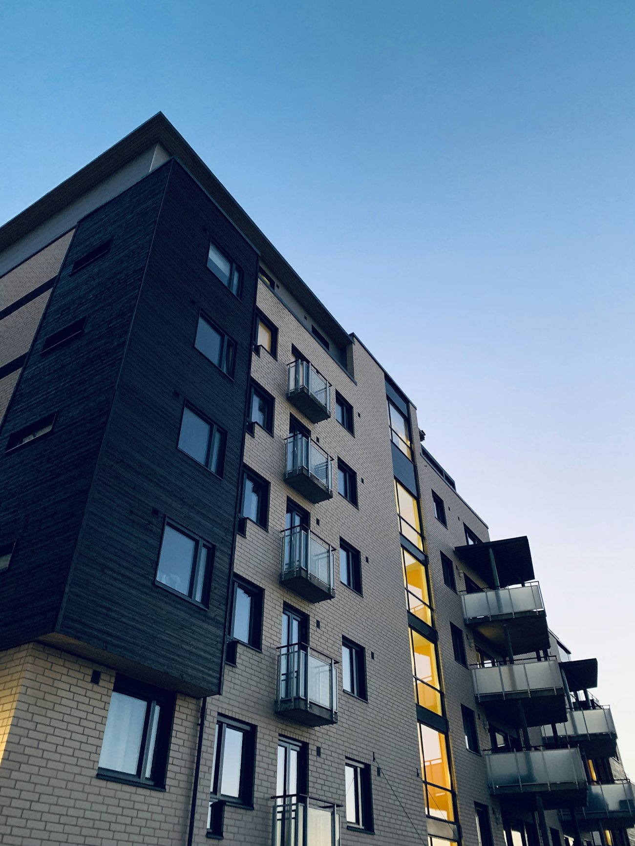 Dark modern apartment tower against a clear sky