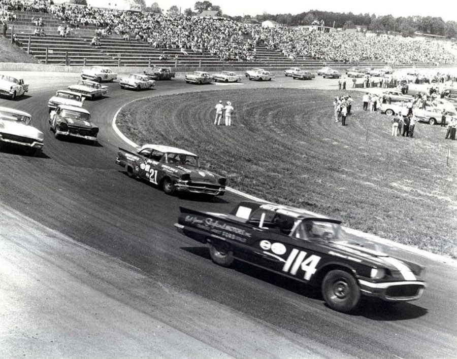 Cursă NASCAR din anii 1950, fotografie alb-negru cu mașini de serie numerotate pe un oval
