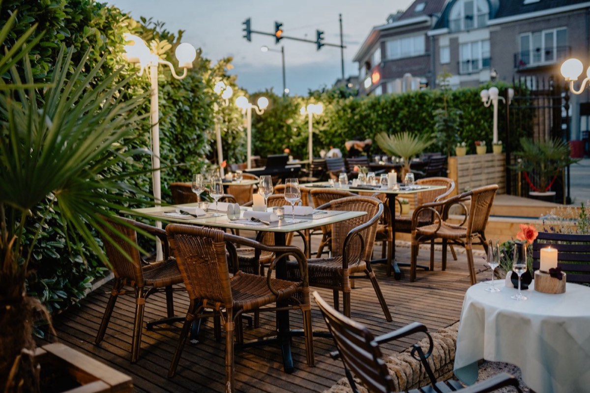 Terasa pizzeriei Vatră seara, cu felinare calde și verdeață